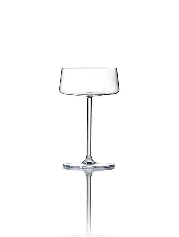 A clear, empty coupe glass from the Lola Glassware Range stands upright on a white background, featuring a wide bowl, slender stem, and subtle reflection for a contemporary look.