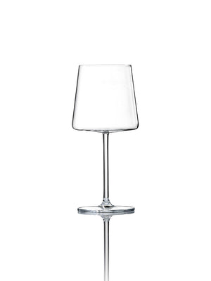 The Lola Glassware Range features a clear, modern wine glass with a broad, flat bowl and slender stem, standing on a reflective white surface against a plain white background.