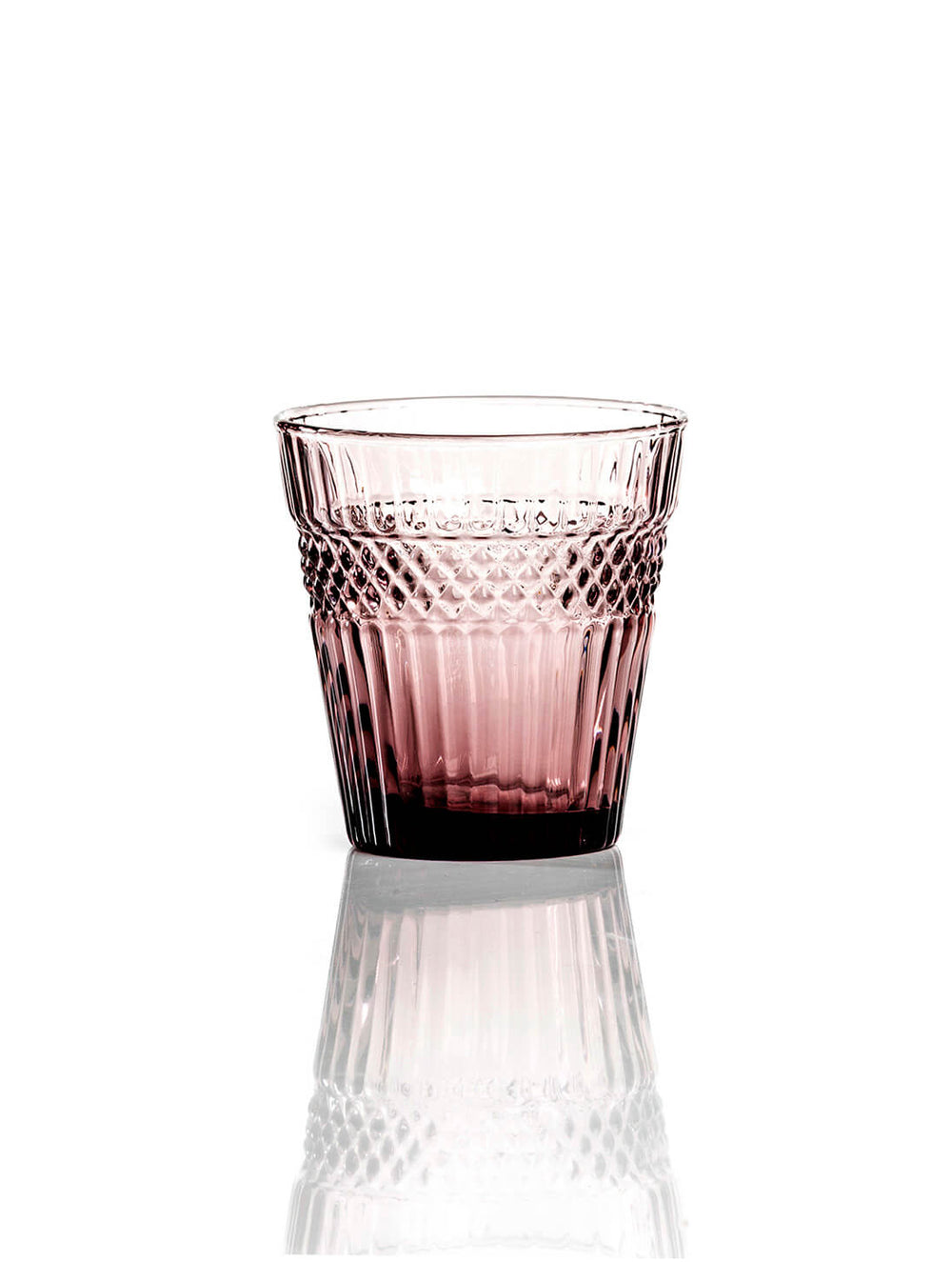 The Margot Pink/Plum Tumbler, crafted from diamond-textured glass with a patterned upper half, sits elegantly on a reflective white surface—an eye-catching piece of modern drinkware.