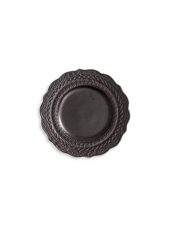 A dark gray plate from the Noir Plate Range, featuring scalloped edges and embossed patterns, displayed from above on a white background.