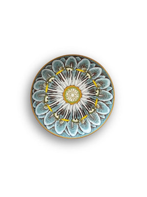 A Paloma Plate Range piece with an intricate blue, white, and yellow floral pattern and a gold mandala-inspired center, shown from above on a white background—ideal for vibrant tableware displays.