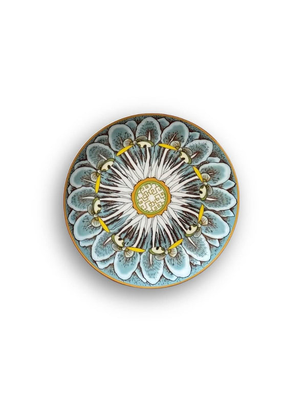 A Paloma Plate Range piece with an intricate blue, white, and yellow floral pattern and a gold mandala-inspired center, shown from above on a white background—ideal for vibrant tableware displays.