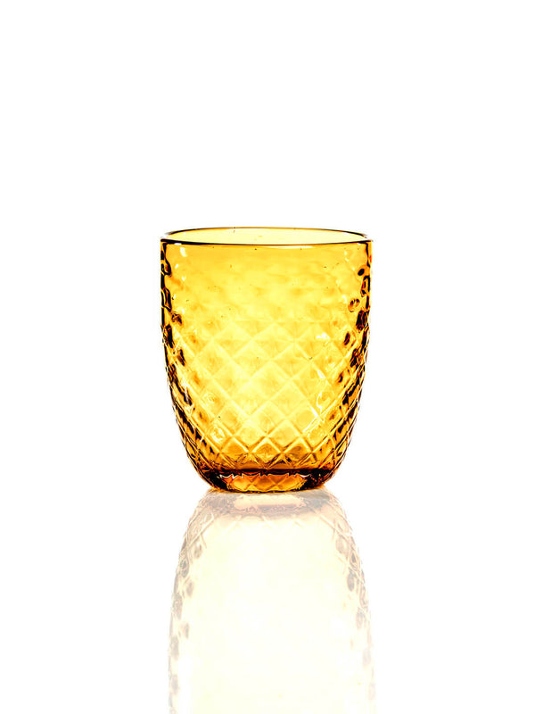 The Prisma Amber Tumbler features a charming faceted design with a textured diamond pattern. Set on a reflective white surface, it's ideal for autumn celebrations and stands out against a plain white background.