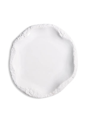A round, white ceramic plate from the Rocca Plate Range, featuring an uneven, textured, slightly jagged rim—ideal for elevating any luxury tableware or fine dining collection.