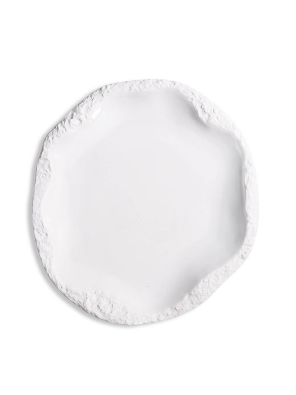 A round, white ceramic plate from the Rocca Plate Range, featuring an uneven, textured, slightly jagged rim—ideal for elevating any luxury tableware or fine dining collection.