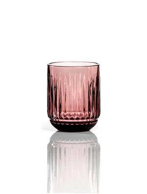 The Sass Plum Tumbler features pink-colored ribbed glass with vertical grooves in a short, wide shape—ideal for adding a modern touch to your tableware collection.