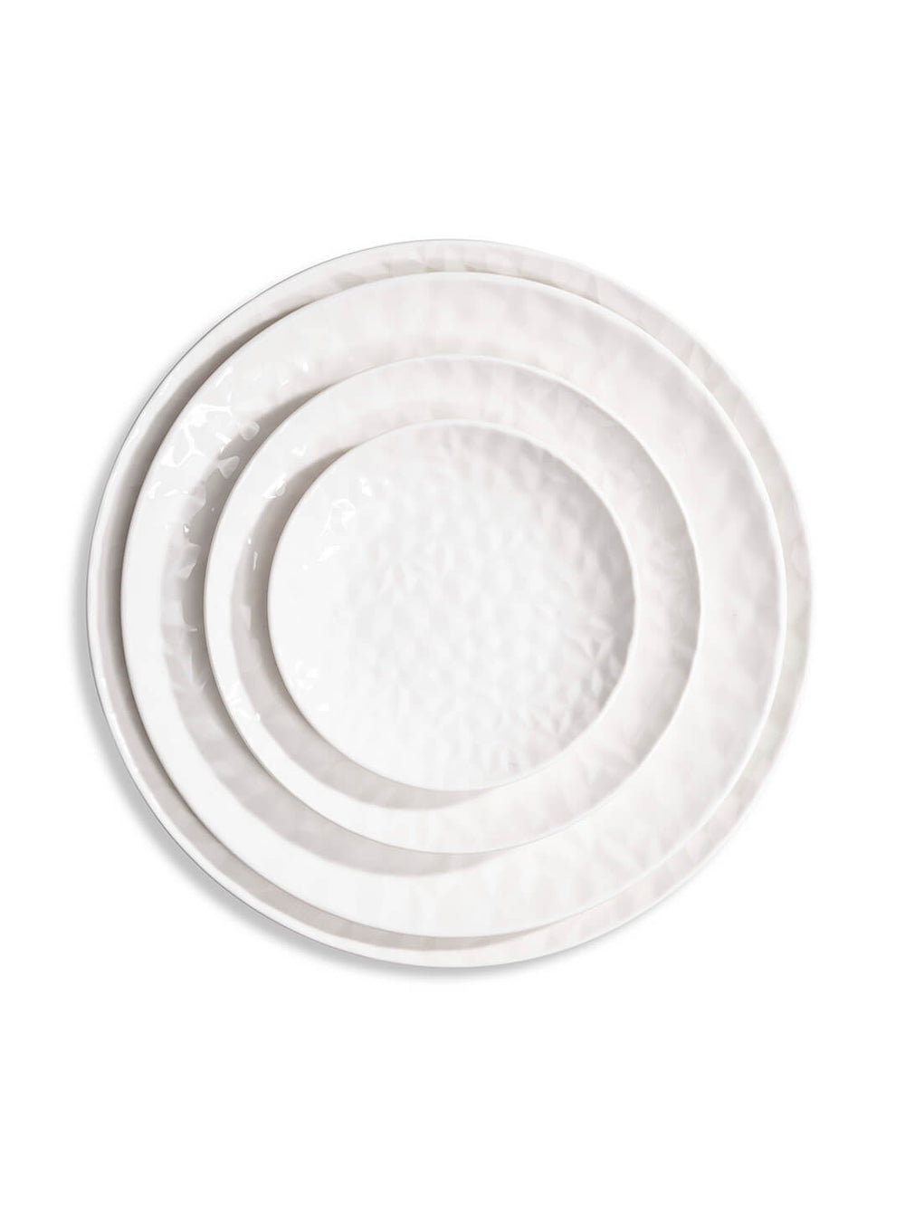 Three white ceramic plates from the Sky Plate Range, each a different size with a subtle hammered texture, are stacked concentrically on a white background.
