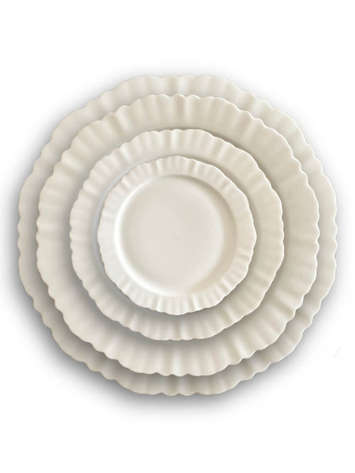 Four white plates from the Sophia Plate Range, featuring ruffled edges, are stacked from largest to smallest and viewed from above against a white background—showcasing elegant dinnerware design.