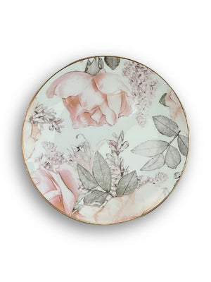 The Vera Plate Range features round ceramic plates with a garden-inspired blush pink rose and gray-green leaf pattern, elegantly finished with a thin gold rim—ideal for chic gold rim dinnerware collections.