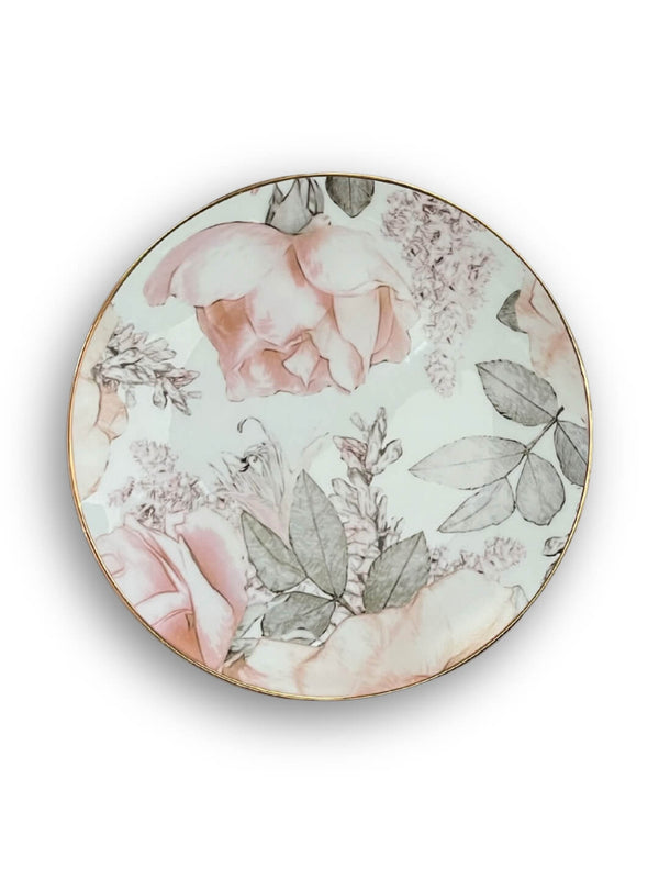 The Vera Plate Range features round ceramic plates with a garden-inspired blush pink rose and gray-green leaf pattern, elegantly finished with a thin gold rim—ideal for chic gold rim dinnerware collections.