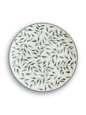 The Willow Plate Range features a round white plate with a green leafy vine pattern, shown from above on a plain white background for an elegant botanical look.