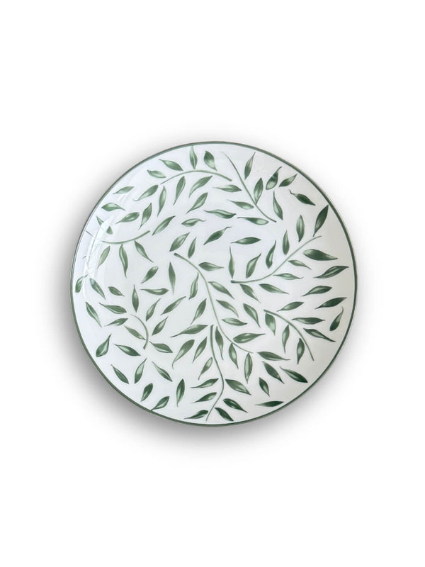 White ceramic plate from the Willow Plate Range, featuring a green leaf and branch motif with a thin dark rim and botanical aesthetic, viewed from above.