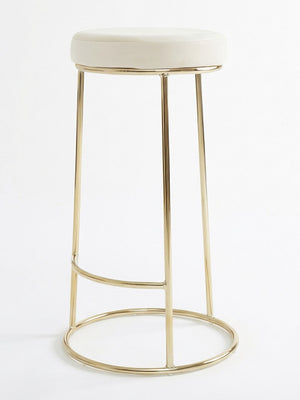 The Astor Bar Stool features a modern design with a round white cushioned seat and a gold metal frame with four legs and circular supports.