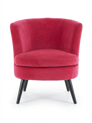 The Berry Chair is a modern lounge chair with a curved backrest, bright pink velvet upholstery, plush seat cushion, and four angled black wooden legs, offering sleek contemporary style as a velvet accent chair.