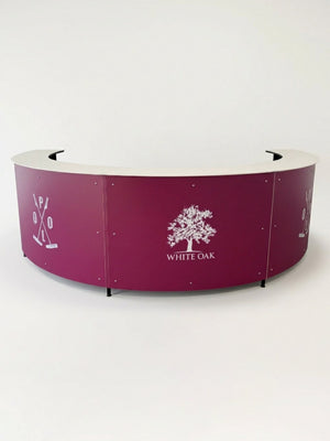 The Bespoke Branded Bar is a semi-circular maroon reception desk with crossed polo mallets on the sides and a central white oak tree illustration featuring the text WHITE OAK—perfect for corporate events or as a custom branded bar.