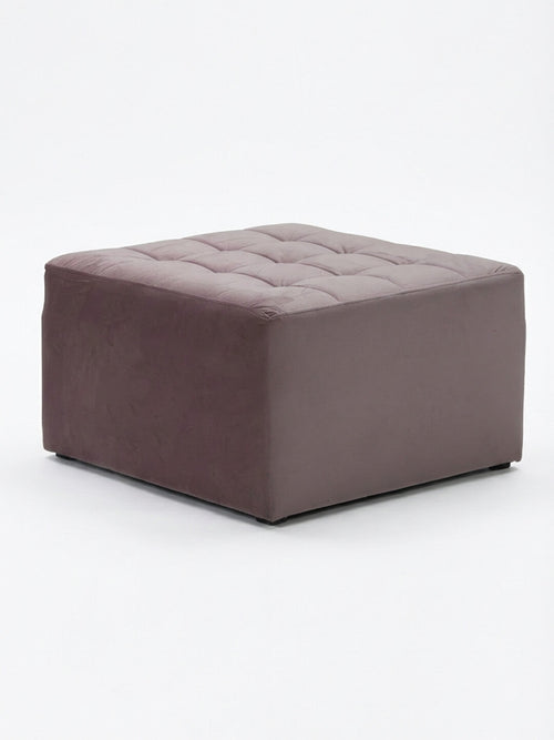 The Cameo Pouffe, a square ottoman in mauve velvet with soft cushioned sides and button-tufted flat top, is featured on a white background—ideal for extra seating or as a vintage-inspired accent.