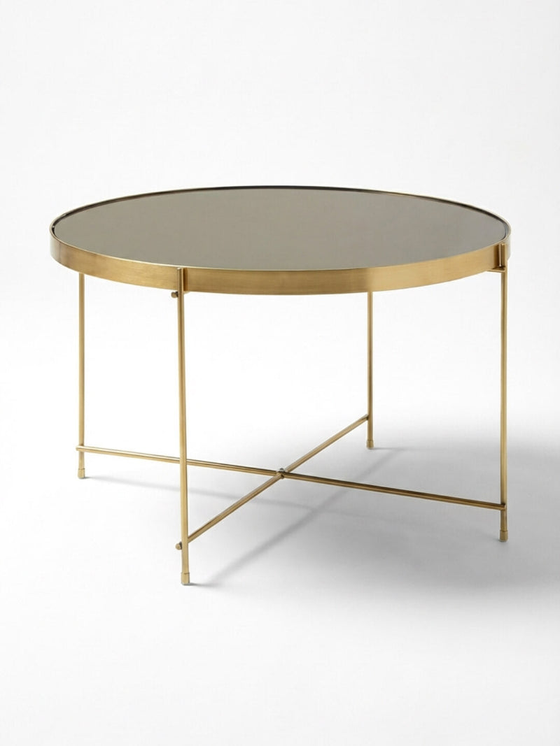 The Capri Coffee Table features a gold metal frame, slim legs, and a reflective glass top for a sleek modern look—an elegant Italian-inspired piece perfect for events.