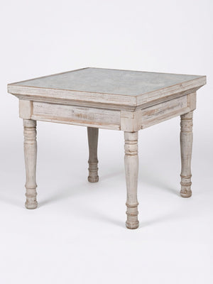 The Chantilly Side Table is a square, rustic wooden table with a weathered finish and four turned legs, adding French elegance as a wedding accent against a plain white background.