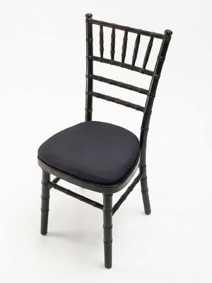 The Chiavari Chair - Black features a black wooden frame with a faux bamboo design and a cushioned black seat, offering stylish event seating. Photographed against a white background.