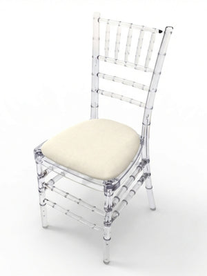 The Chiavari Chair - Ice features a clear acrylic bamboo-style frame and a light beige custom seat pad, ideal for stylish event seating, shown against a plain white background.
