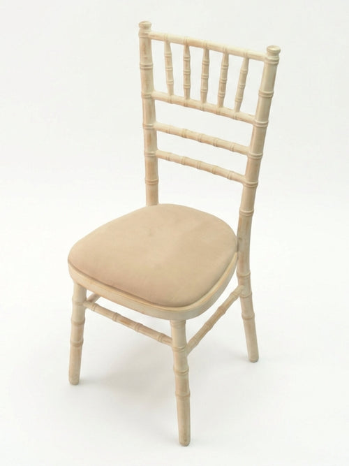 The Chiavari Chair - Limewash features a light-colored frame, ladder-style backrest, and cushioned beige seat, ideal for event seating and shown against a plain white background.