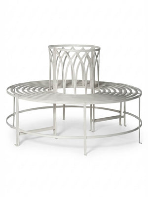 The Circa Seat is a round, silver metal garden bench with an open center and decorative backrest, designed to wrap around the base of a tree for stylish outdoor seating.