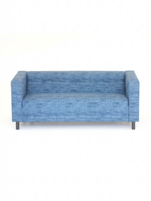 The Coast Sofa is a modern blue velvet piece with square arms and black legs, showcased against a plain white background.