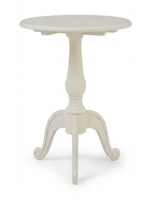 The Colette Side Table is a compact, round table with a central pedestal and three curved legs, finished in distressed white for a vintage Parisian charm.