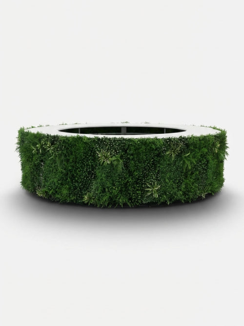 The Foliage Bar is a large, circular bar wrapped in lush green plants, forming a natural living surface around its sides against a plain white background.