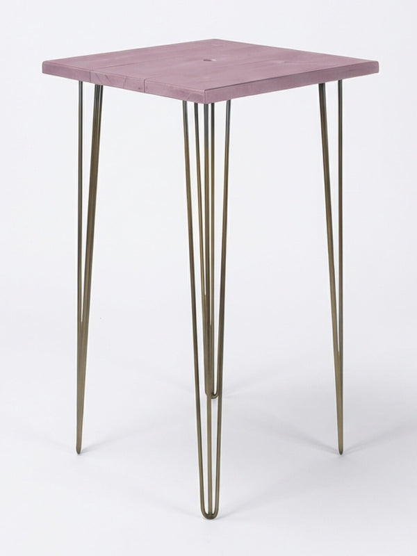 From the Hairpin Bar Table Collection, this minimalist side table has a square light purple wooden top and four slim gold hairpin legs—perfect as colorful event furniture against a plain white backdrop.