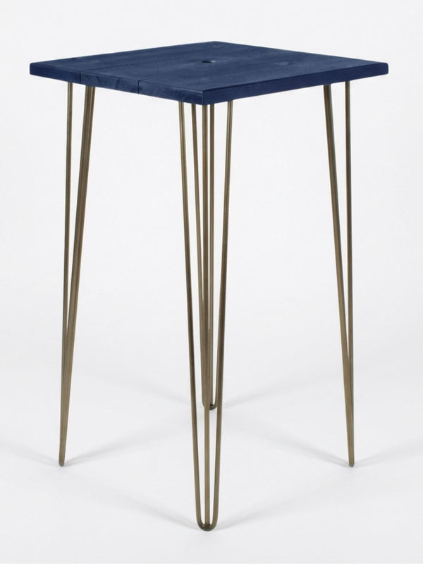 From our Hairpin Bar Table Collection, this compact square table has a dark blue wooden top and four gold hairpin legs—perfect as a chic bar table or colourful event furniture against a plain white background.