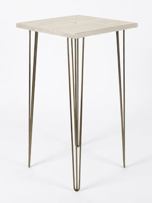 A compact square table from the Hairpin Bar Table Collection, featuring a light wood top and three slim brass-finished legs, displayed against a plain white background.