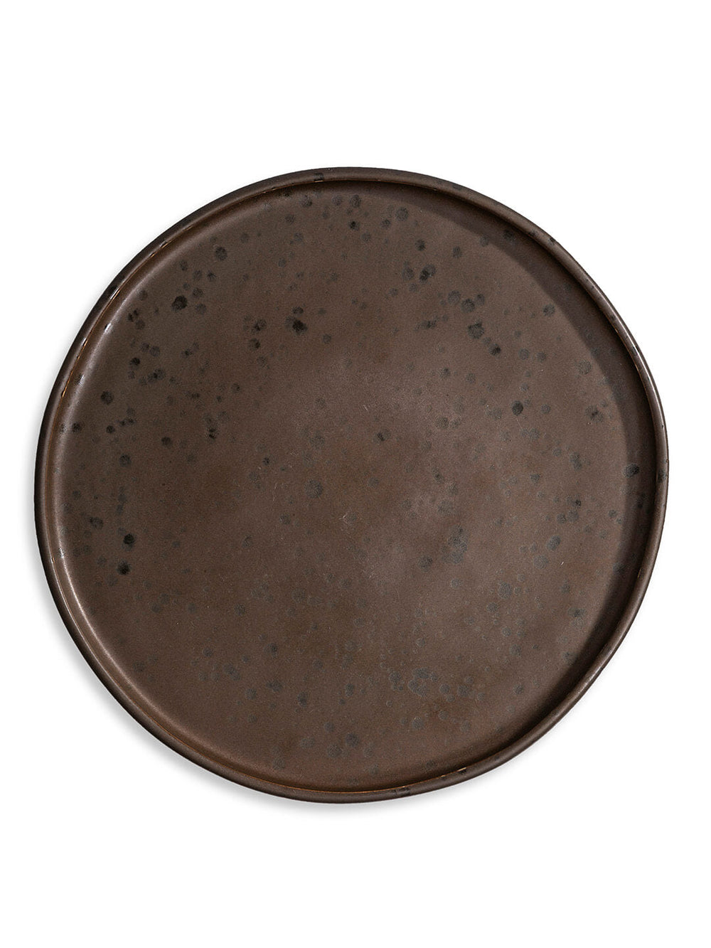 The Juniper Charger Plate is a handcrafted, round, dark brown charger with an uneven rim and subtle black speckles that adds rustic charm to any table setting, presented against a white background.