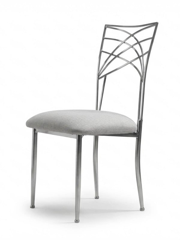 The Lattice Chair features a light gray cushioned seat and a decorative geometric backrest. Its four slender legs and minimalist design make it ideal for contemporary spaces and modern events.