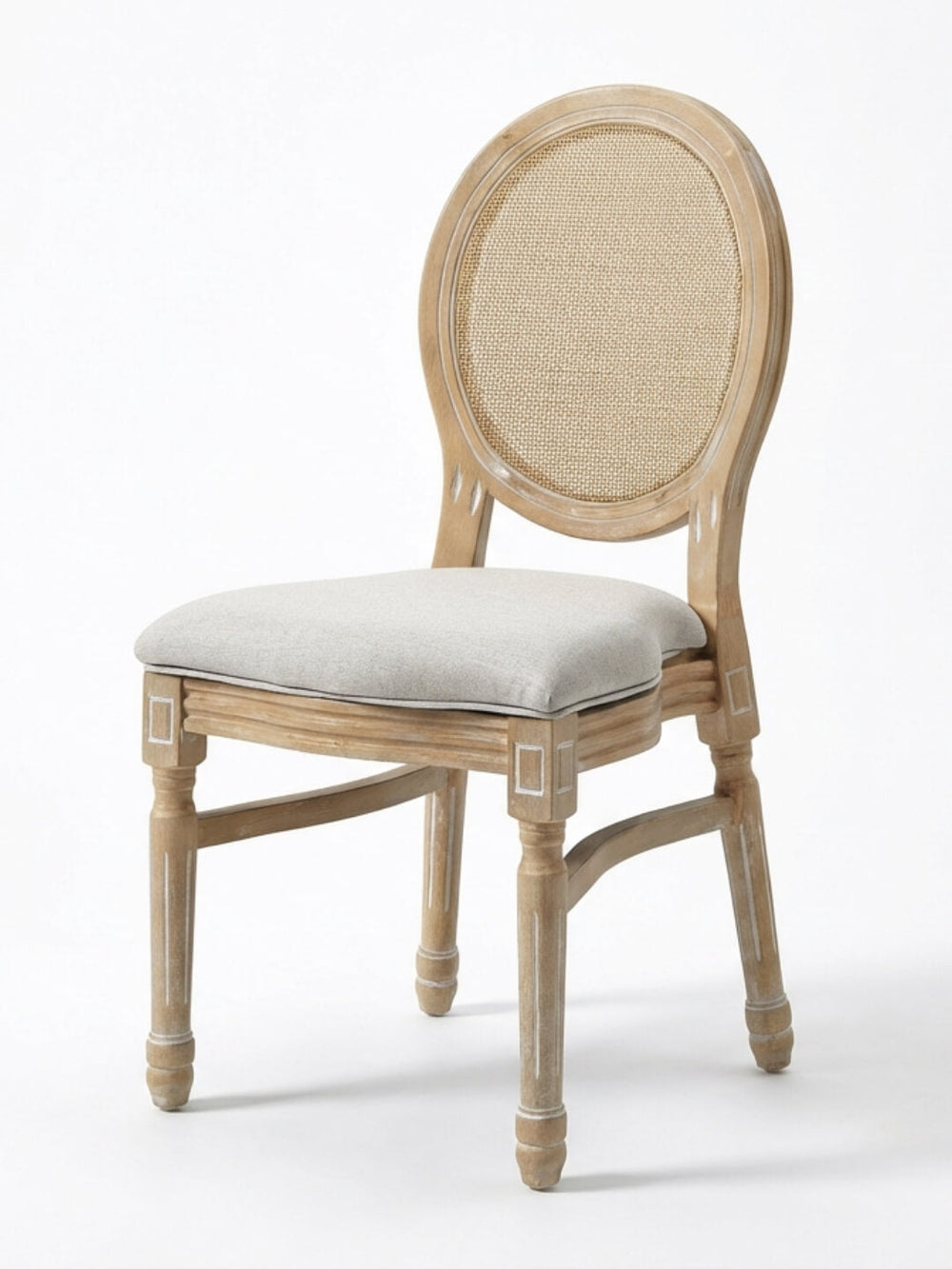 The Louis Rattan Chair features a natural wood finish with subtle white accents, a round cane backrest, cushioned light gray seat, carved details, and elegant French-inspired design.