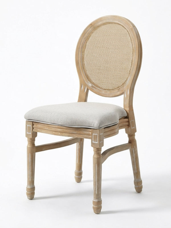 The Louis Rattan Chair features a natural wood finish with subtle white accents, a round cane backrest, cushioned light gray seat, carved details, and elegant French-inspired design.
