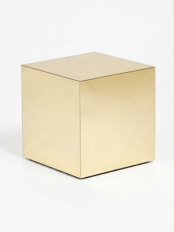A polished, gold-colored metallic cube from the Luxe Cube Collection with smooth, reflective surfaces rests on a plain white background—perfect as event furniture or a striking accent to modern cube tables.