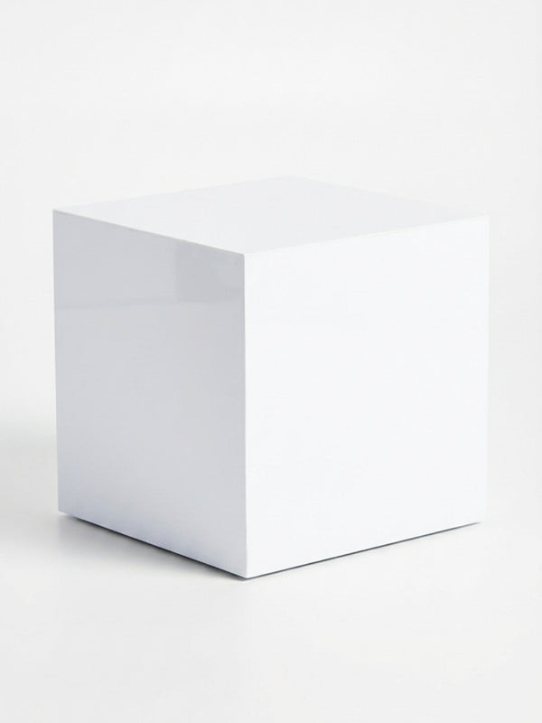 A glossy white table from the Luxe Cube Collection sits on a white surface with a faint shadow cast to one side against a white background.