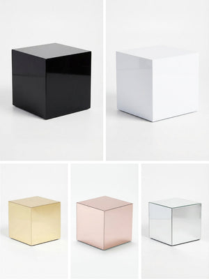 The Luxe Cube Collection features five glossy cube tables in black, white, gold, rose gold, and silver arranged in a grid on a white background—ideal for enhancing any event furniture setup.