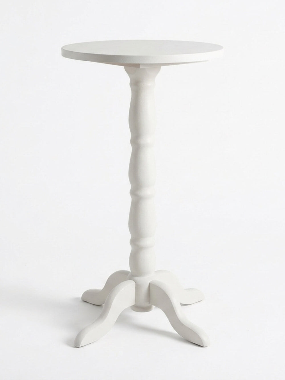 The Maison Bar Table is a small, round, French-inspired piece featuring a turned central column and three curved legs in whitewashed wood, displayed against a plain white background.