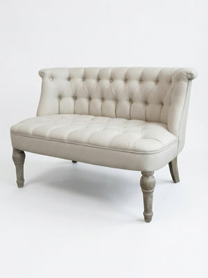 The Maison Sofa loveseat showcases French elegance with light gray linen upholstery, a tufted curved backrest, wooden legs, and an upholstered seat, displayed against a plain white background.