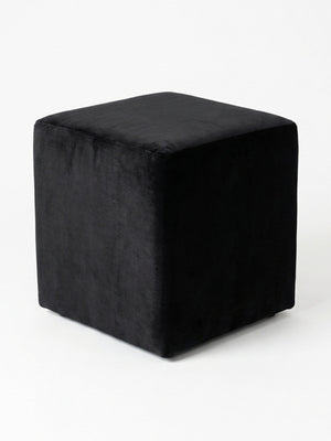 The Noir Cube, a sleek black velvet ottoman, is displayed on a plain white background and offers stylish minimalist seating for modern spaces.