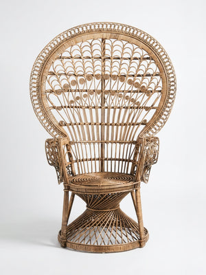 The Peacock Chair features a tall, ornate design with a large rounded backrest, intricate woven patterns, curved armrests, and a circular seat, shown here against a plain white background.