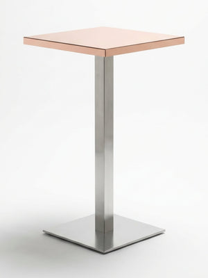 The Reflection Table Collection features a modern, minimalist table with a square light brown top and a single metallic pedestal base on a square platform—ideal luxury bar furniture for refined spaces.