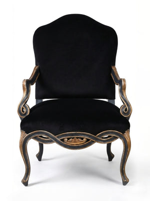 The Rococo Noir Chair features a black velvet seat, high rounded back, ornate carved wooden frame, and curved arms and legs, capturing French palace elegance against a white backdrop.