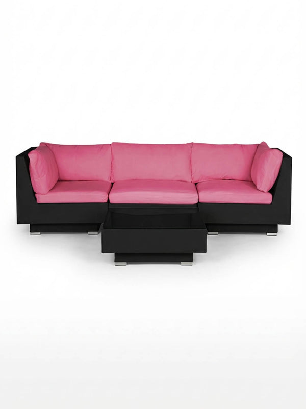 The Sereno Black is a modern modular L-shaped sofa in black, featuring bright pink cushions and pillows, paired with a matching black coffee table. This contemporary outdoor set is displayed against a plain white background.