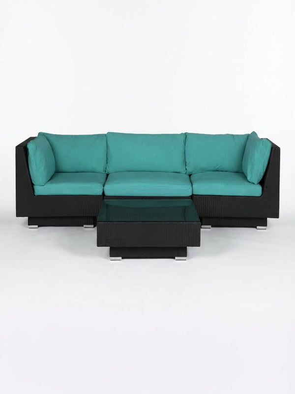 The Sereno Black modular outdoor rattan sofa set features teal cushions and a matching low square coffee table, ideal for contemporary spaces and shown against a plain white background.