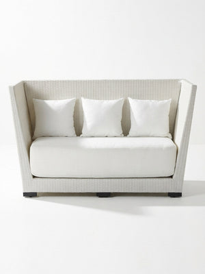 The Sereno High Back is a modern white modular rattan sofa with high angled sides, a low back, thick seat cushion, and three square white pillows—ideal for outdoor privacy seating—shown against a plain white background.