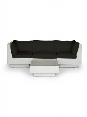 The Sereno White modular sectional sofa with black cushions and a matching rectangular coffee table is showcased on a plain white background, offering stylish outdoor lounge furniture.