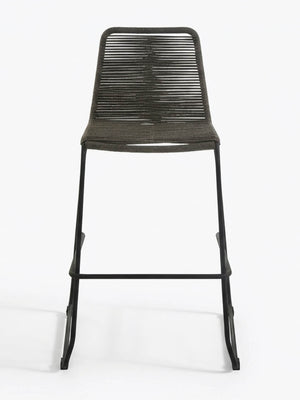 The Tide Bar Stool features a black metal frame with a tightly handwoven dark rope seat and backrest, shown against a plain white background—ideal for stylish outdoor bar seating.